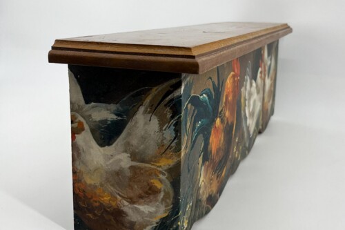 Decorative wooden box with a light lid resting on the side and a colorful painted panel on the curved side.