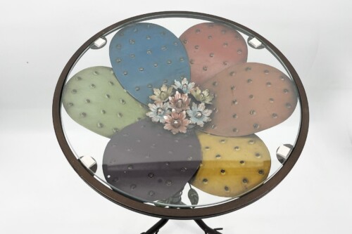 Round glass-top table featuring overlapping colorful prickly pear cactus pads arranged like petals with a flower cluster in the center.