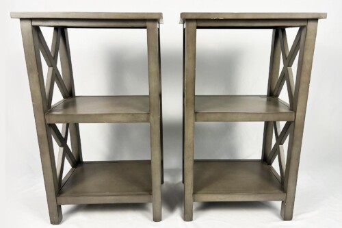Pair of brushed metal stools with crisscross X-brace legs, placed side by side against a white backdrop.