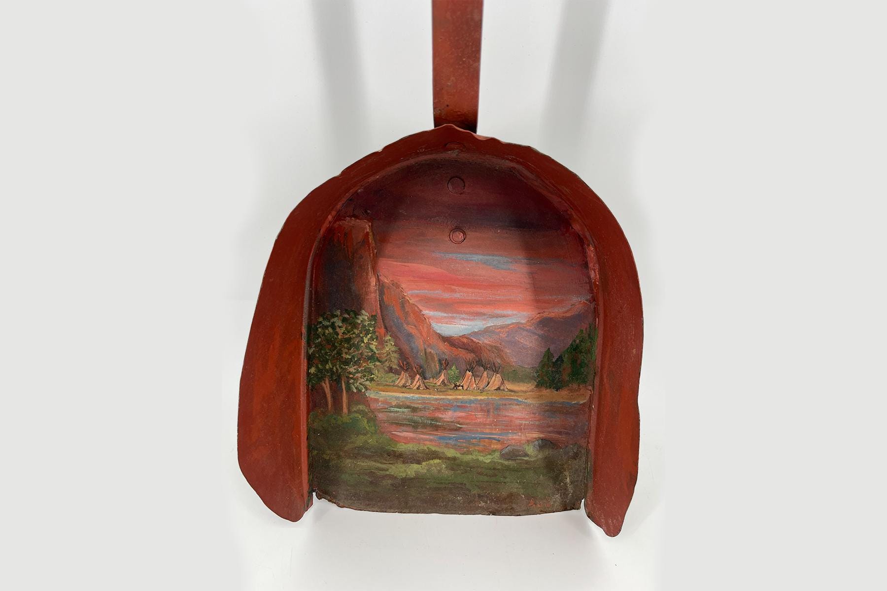 Red oval wooden panel with a painted canyon landscape (tents, river, trees) inside.