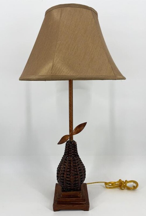 Table lamp with a woven dark brown pear-shaped base, wooden stem, beige shade, and a visible yellow power cord.