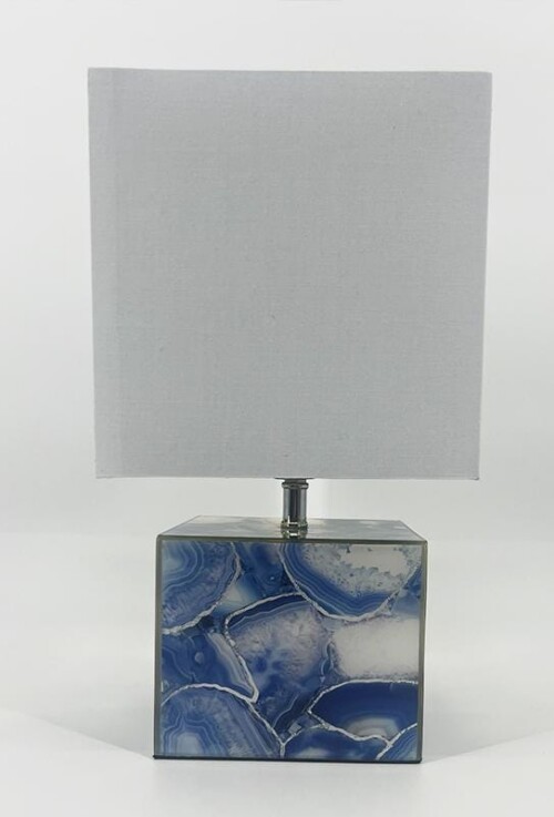Table lamp with a square gray lampshade and a blue geode-patterned base.",
