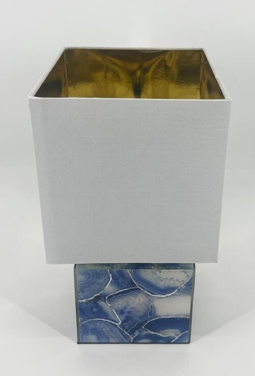 Two decorative boxes stacked: a tall white textured box with a gold interior on top of a smaller blue marble-patterned box.