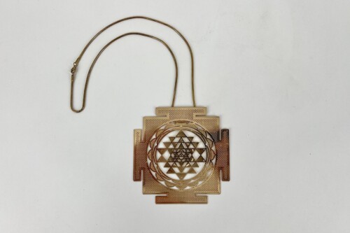 Gold-toned square pendant with a circular, intricate geometric Sri Yantra design inside, hanging on a thin gold chain