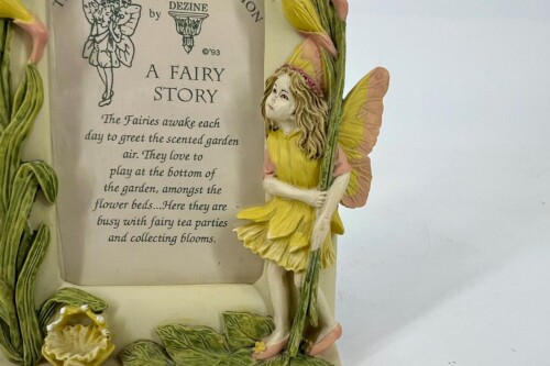 Decorative fairy figurine in a yellow dress with pink wings beside a page titled 'A Fairy Story' and surrounding vines.