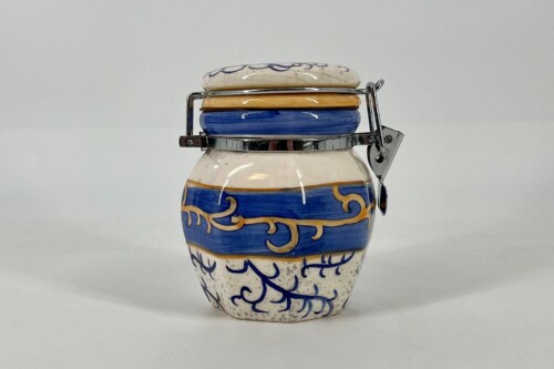 Decorative ceramic jar with a blue and gold scroll pattern and a metal hinged lid building a clasp.