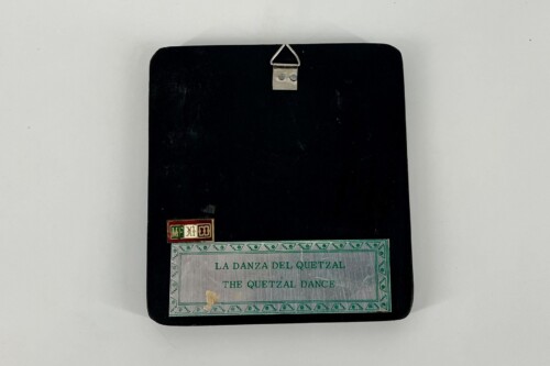 Black notebook with a decorative label reading 'LA DANZA DEL QUETZAL THE QUETZAL DANCE' and a small 'MEXICO' sticker, plus a metal hanger at the top center.