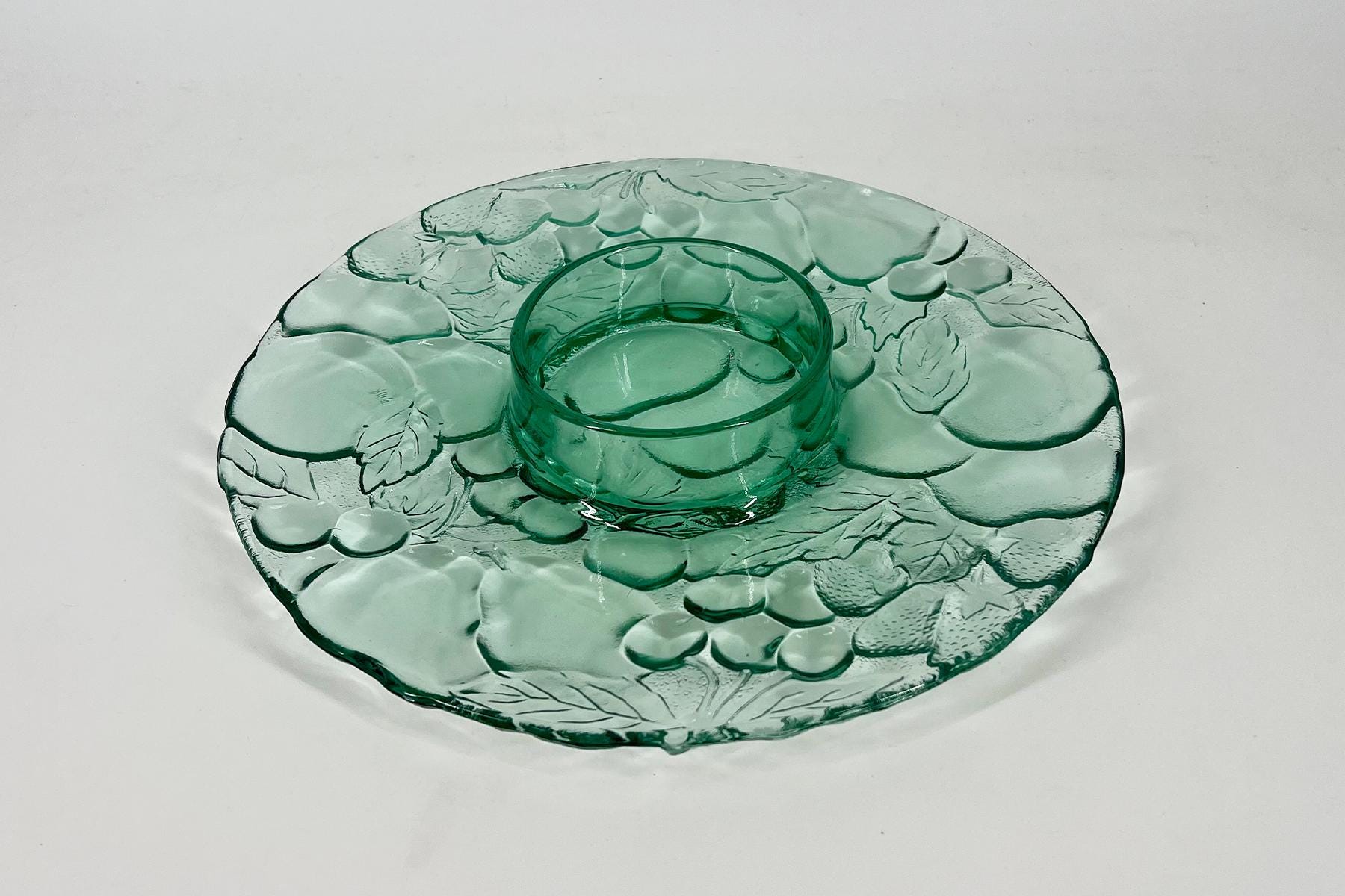 Green embossed glass plate with a leaf pattern and a small matching glass bowl in the center