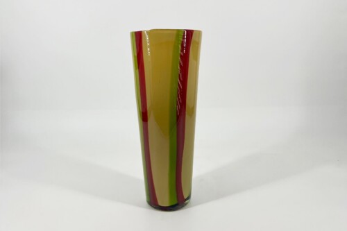 Tall glass vase with vertical red, green, and yellow stripes on a white background.