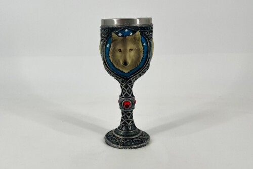 Ornate metal goblet with a wolf head emblem set in a blue circular frame and a red gemstone on the stem