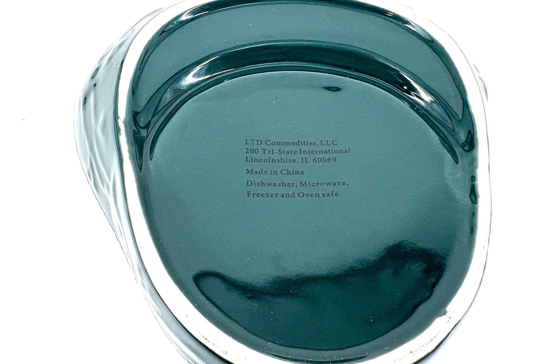 Close-up view of a teal plastic lid with stamped text: LTD Commodities, LLC; 200 Tri-State International, Lincolnshire, IL 60069; Made in China; Dishwasher, Microwave, Freezer and Oven safe.