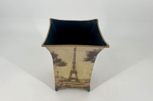 Tall decorative vase with Eiffel Tower print and dark interior, standing on small metal feet.