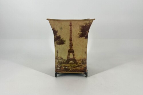 Decorative vase with Eiffel Tower print and vintage map background, standing on ornate metal feet.
