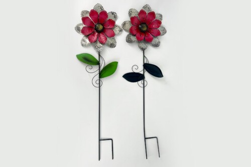 Two decorative metal flower sculptures with red petals, green/dark leaves, and tall black stems against a pale background.