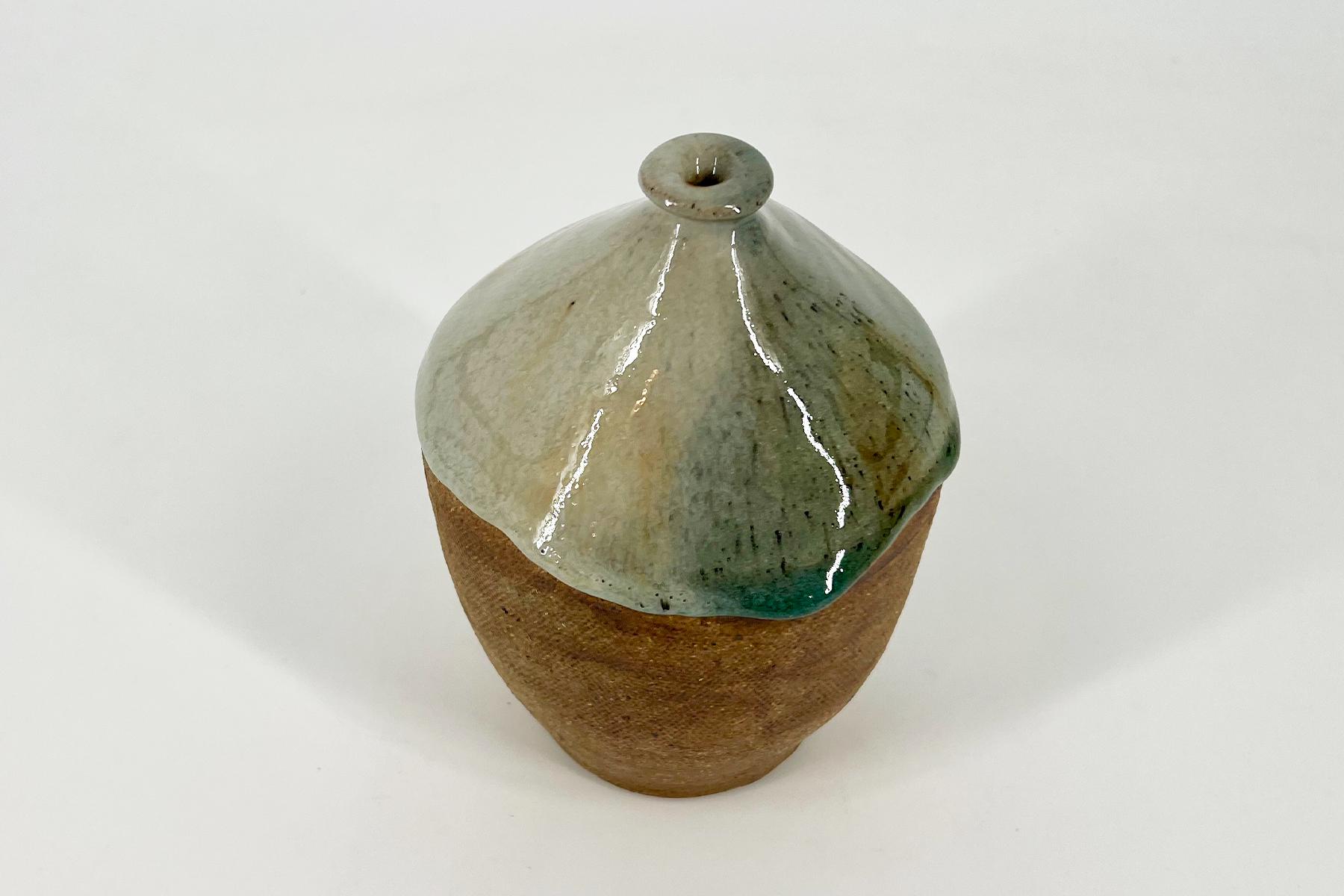Ceramic ice-cream-cone sculpture with a glossy pale green glaze scoop on a brown textured cone.