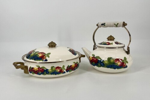 Two white porcelain teaware pieces with brass handles and fruit-patterned decoration.