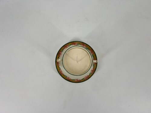 Top-down view of two decorative plates stacked with a white candle in the center.