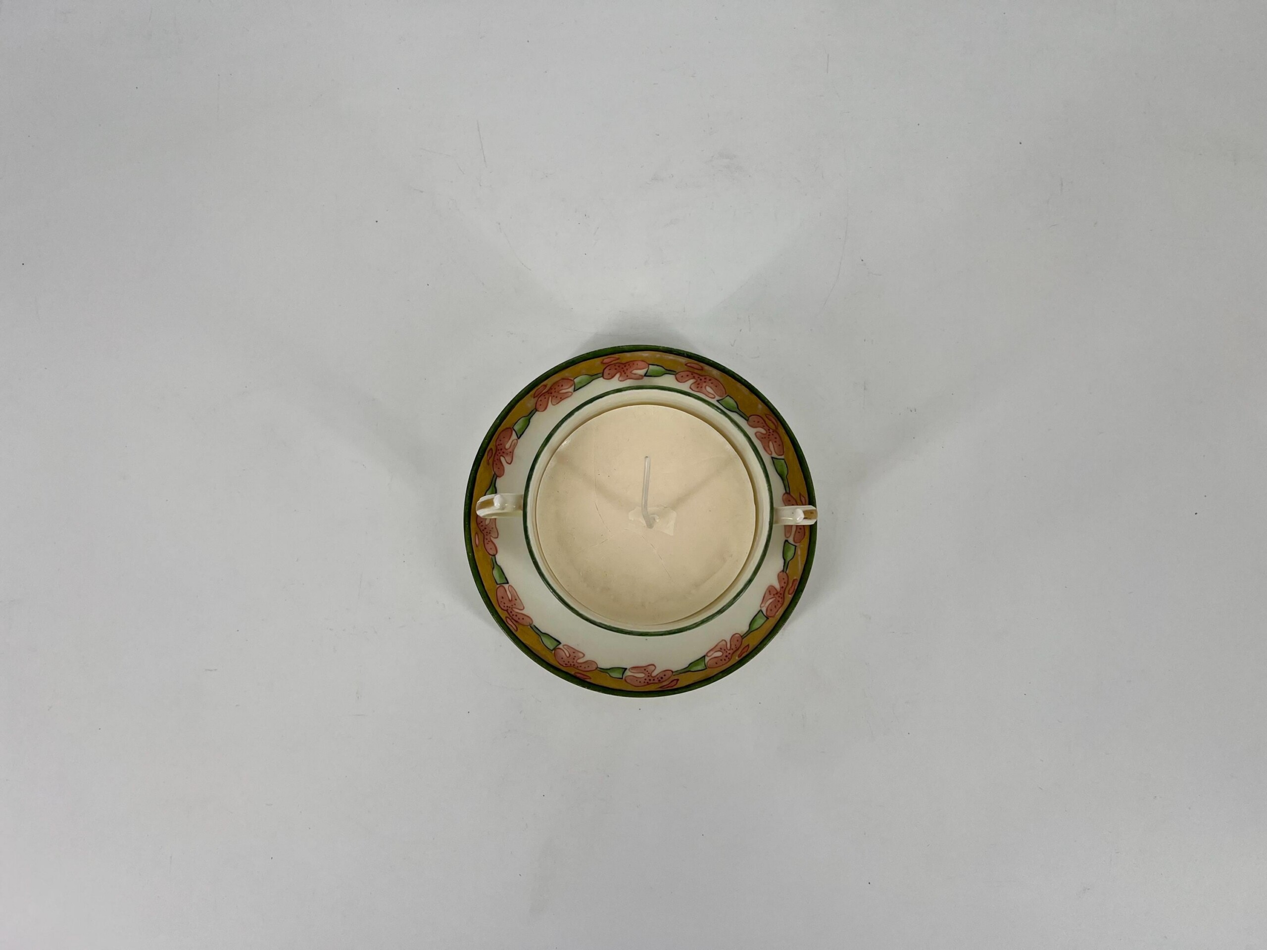 Top-down view of two decorative plates stacked with a white candle in the center.