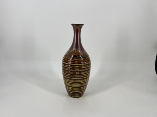 Ceramic vase with a narrow neck, brown glaze, and horizontal tan rings on a white background.