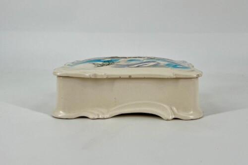 Cream ceramic tissue box cover with a hinged, decorative lid featuring blue and black brushstroke design