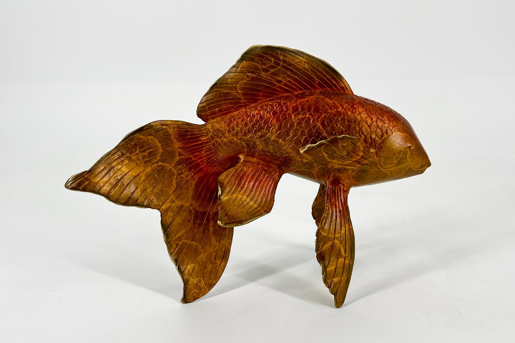 Carved wooden fish sculpture with detailed scales and fins, standing on a white surface.