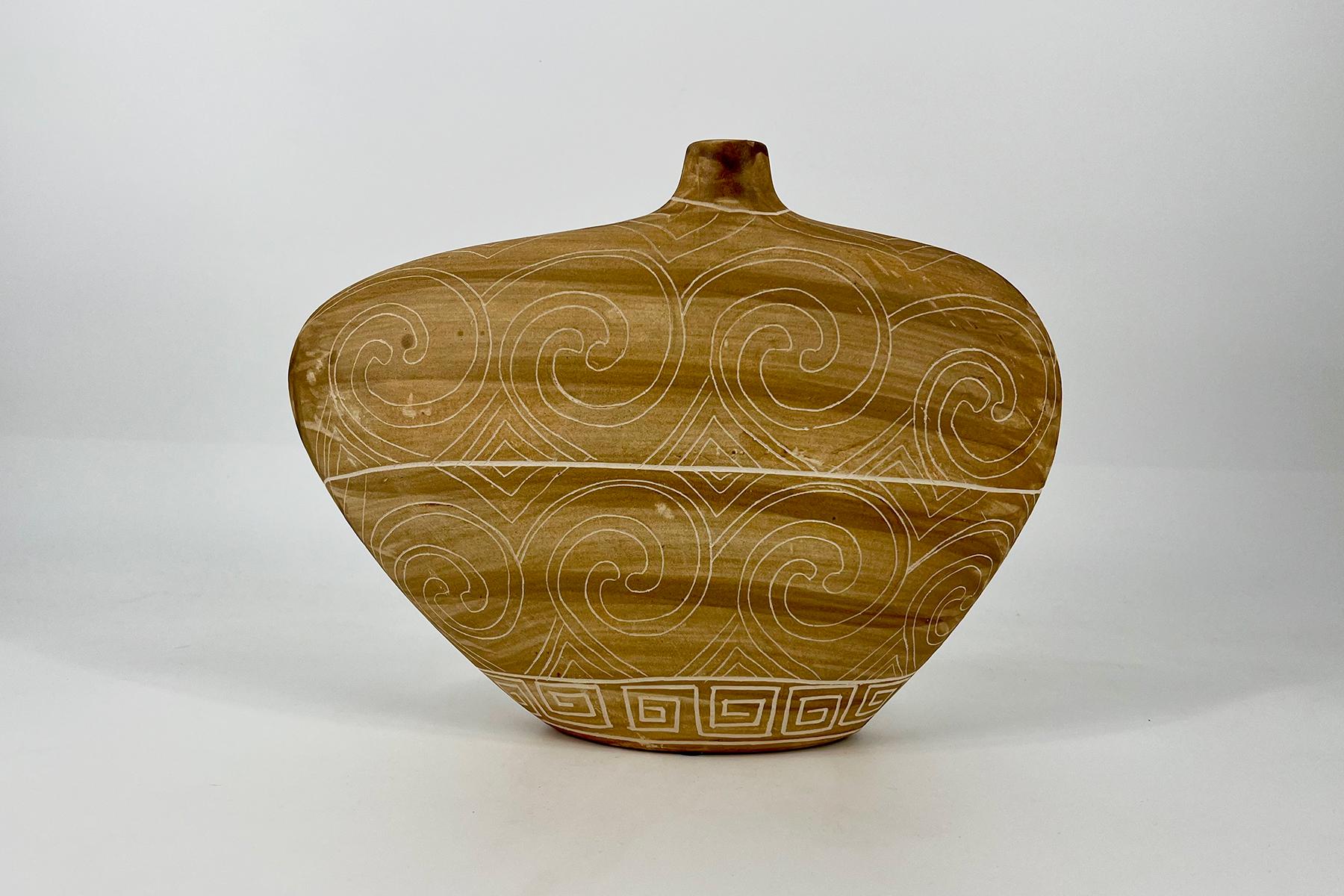 Ceramic vase with a wide rounded body and top neck, decorated with white spiral patterns on a light brown glaze, set against a neutral background.