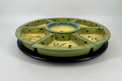 Six-section ceramic serving platter with a central ring, olive-green with leaf patterns, used for holding dips or appetizers.