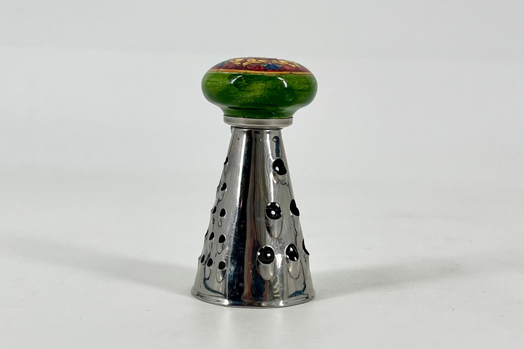 Close-up of a champagne cork with a round green seal atop a silver perforated foil neck.