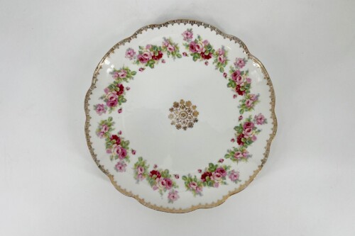 White porcelain plate with pink rose garland along a scalloped gold edge and a gold center medallion.