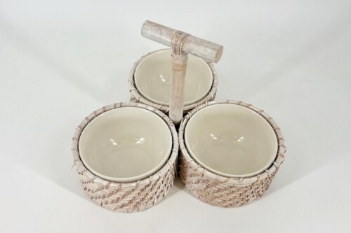 Three beige ceramic bowls placed in light wicker baskets arranged around a central wooden handle piece for serving or display
