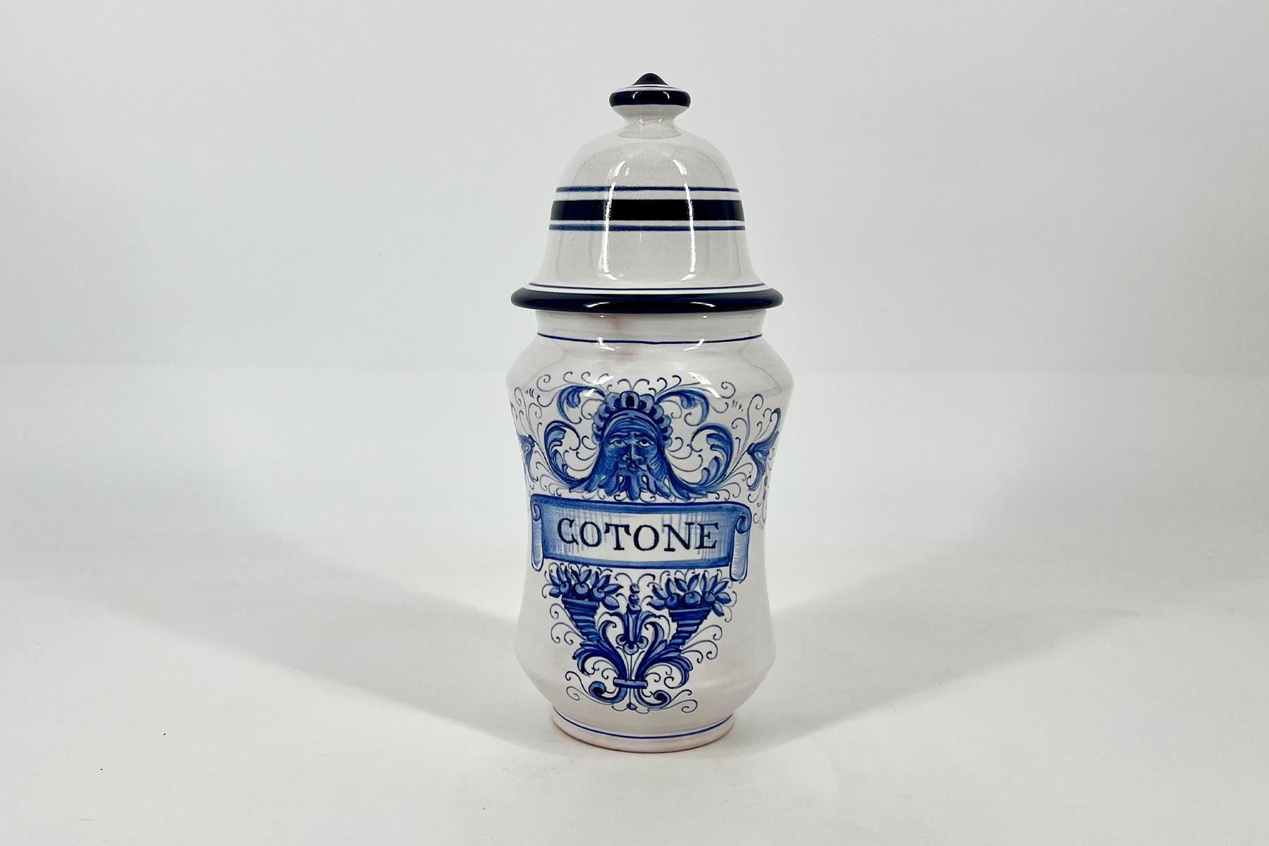 White ceramic shaker with a lid and blue decorative patterns, labeled 'COTONE'.