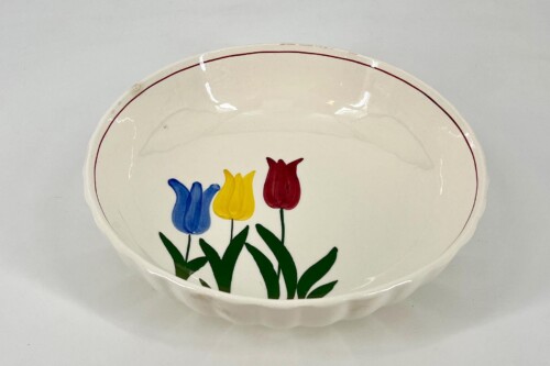 Decorative ceramic plate featuring a trio of tulips in blue, yellow, and red with green stems and a thin red rim (white background).
