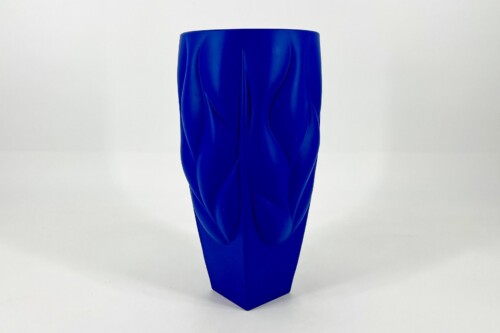 Blue vase with raised, twisting ridges carved into its surface, standing on a white background.