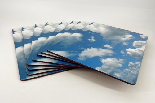 Stack of glossy cards arranged in a fan, each with a blue sky and white clouds design.