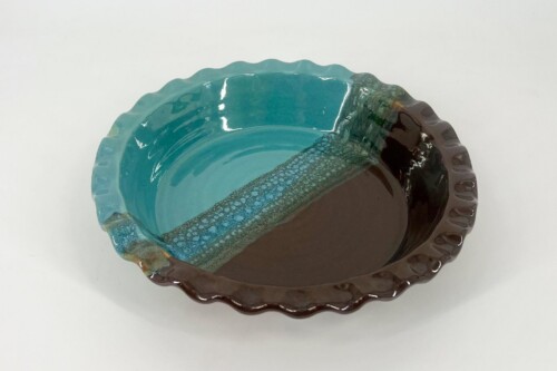 Turquoise-glazed ceramic bowl with a brown scalloped rim and glossy finish.
