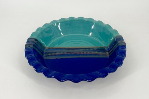 Scalloped-edge ceramic bowl with turquoise to deep blue glaze and glossy finish