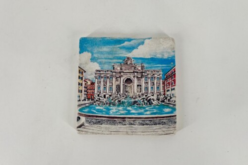 Vintage postcard showing a grand neoclassical building with sculpted figures and a large fountain in front, under a blue sky with colorful surrounding buildings.