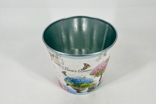 Decorative metal bucket with a blue floral pattern and butterflies, viewed from above showing a dark green interior.