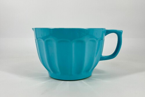 Teal ceramic mug with a curved handle, viewed from the side on a white surface.