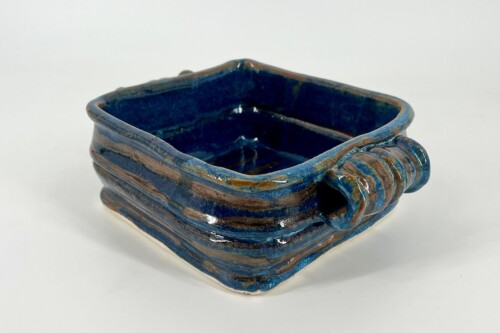 Blue glazed square ceramic dish with a ribbed handle on the right side.