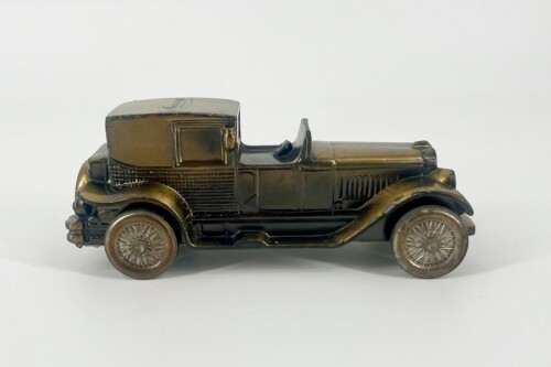 Bronze-toned vintage toy car shown in profile with open cockpit and spoked wheels