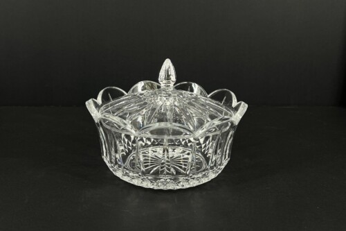 Crystal glass candy dish with a domed lid and faceted pattern on a dark background