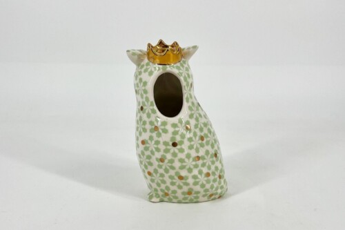 Decorative ceramic cat figurine with a gold crown, pale green floral pattern, and copper-dot accents against a plain background.