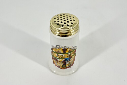 White ceramic bottle topped with a gold perforated shaker lid, showing a colorful cheese label and Italian art motif